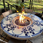 Fire pit table with a burner and wind guard placed in the porcelain tabletop