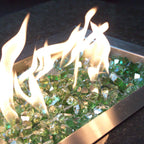Terrestrial Green 1/2" Tempered Reflective fire glass in a fire pit burner pan